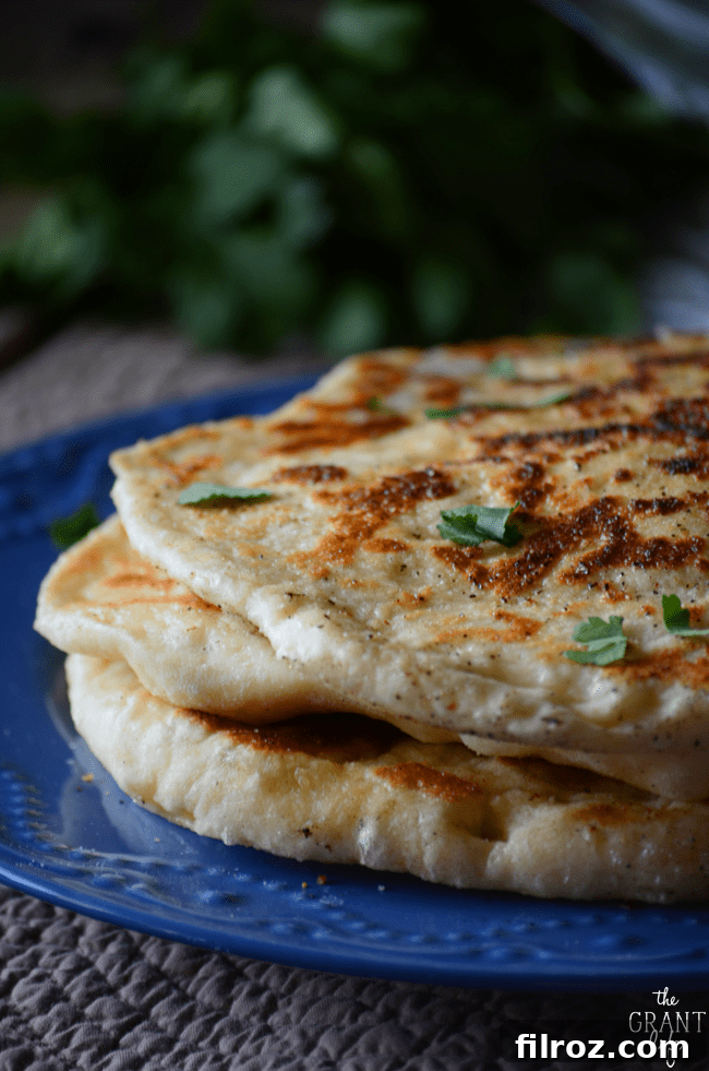 Homemade naan bread fresh off the skillet, golden brown and fluffy.