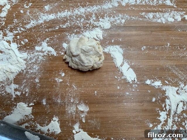 Divided naan dough balls on a floured surface, ready for rolling.