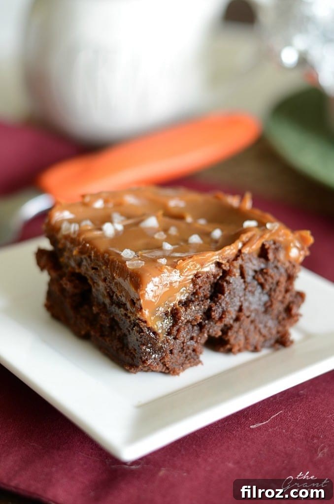 A close-up of a pan of golden brown caramel brownies cooling on a wire rack.