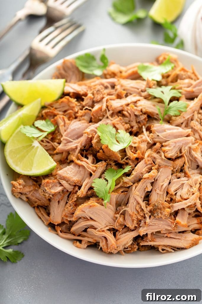 Pork carnitas in a bowl with celery and lime wedges, ready to serve