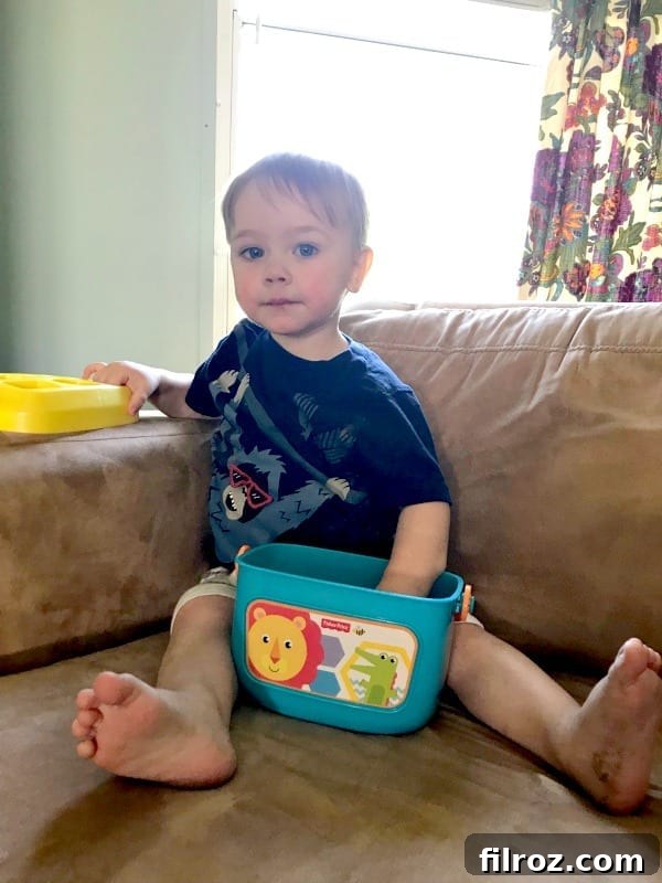 Toddler playing with colorful stacking rings from Fisher-Price