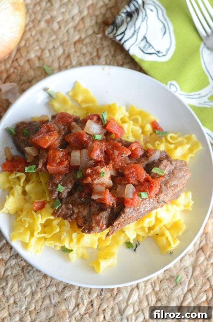 Tender Crock Pot Swiss Steak, served with gravy.