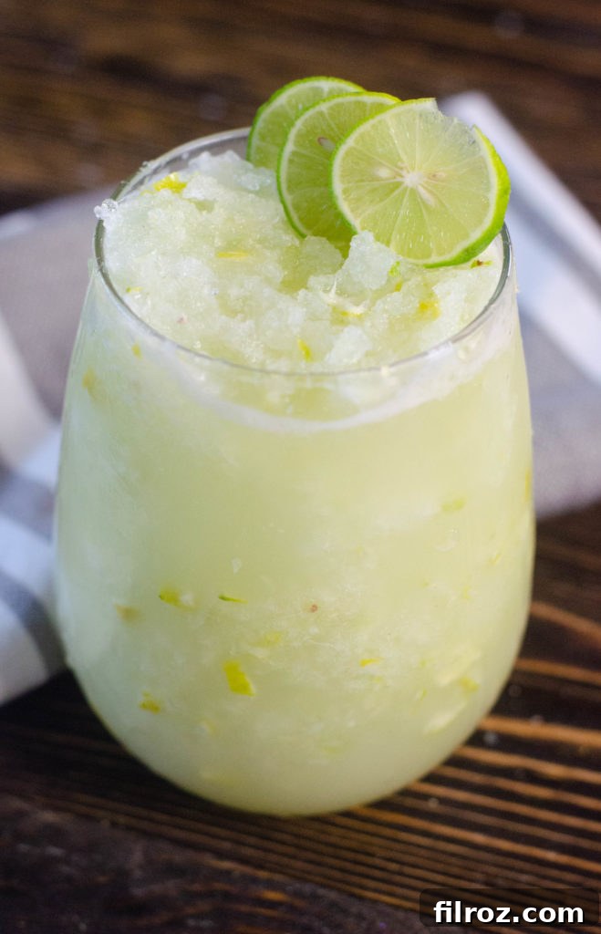 Close-up of a key lime slush drink in a glass with a lime wedge