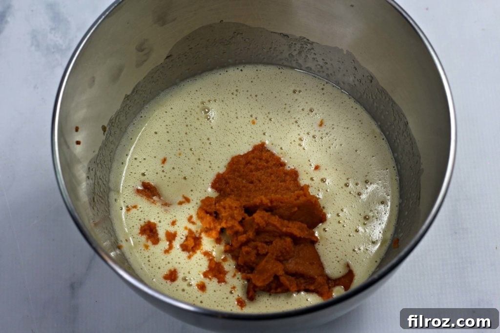 Mixing wet ingredients for pumpkin bread batter in an electric mixer
