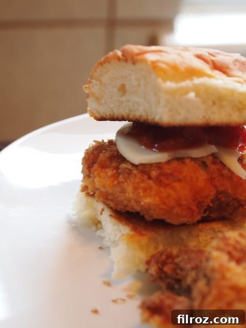 Close-up of a stack of golden-brown chicken parmesan sliders, showcasing the melted cheese.
