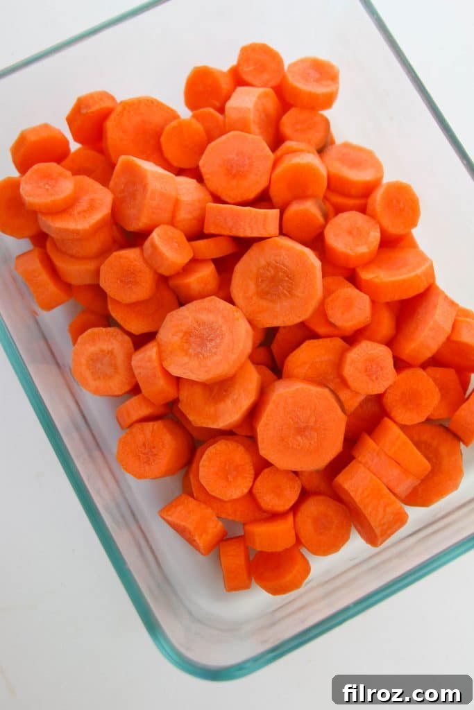 Chopped carrots on a roasting pan ready for seasoning