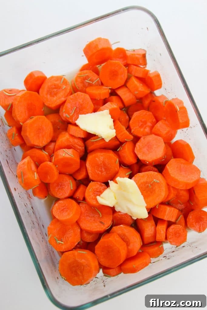 Drizzling melted butter over carrots before roasting
