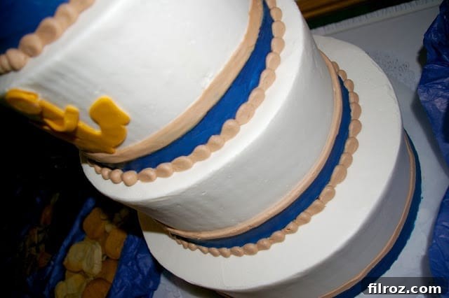 Close-up view of the multi-tiered wedding cake, showcasing the intricate anchor design and smooth buttercream frosting, emphasizing its pristine condition.