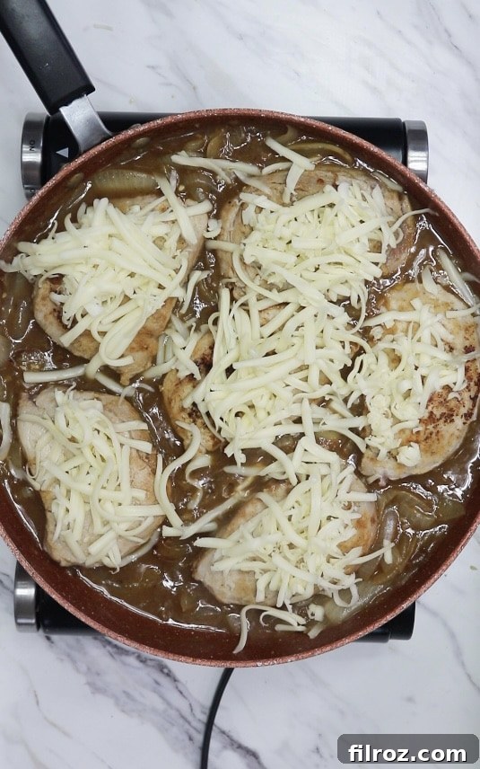 French Onion Smothered Pork Chops 9 mozzarella cheese covered pork chops in a skillet