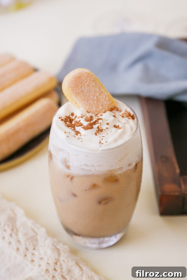 Iced tiramisu latte with a lady finger, ready for a review or to be pinned.